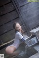 A woman in a white bodysuit sitting in a pool of water.